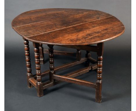 A late 17th/early 18th century oak gate leg dining table, oval top, turned legs, rectangular stretchers, 71cm high, 109cm wid