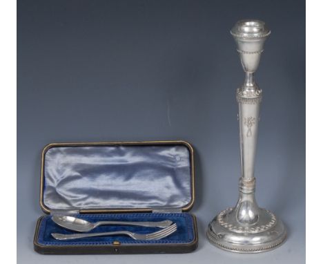 An Edwardian silver christening set, comprising child's fork and spoon, Sheffield 1906, cased; a silver candlestick, applied 