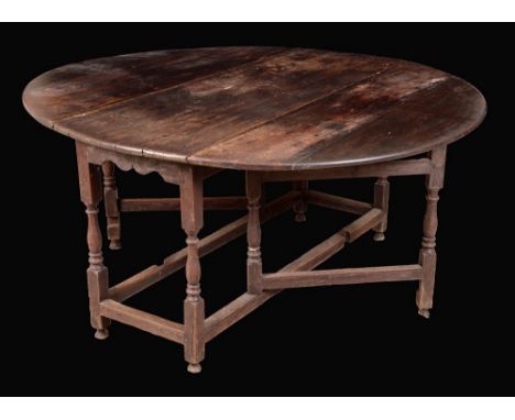 An early 18th century oak gate leg dining table, oval top, turned legs, 72cm high, 137cm wide, c.1720