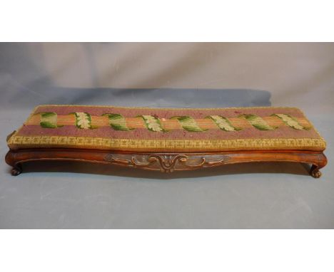 A 19th century French mahogany fire place foot stool with tapestry upholstery raised on cabriole legs. 
