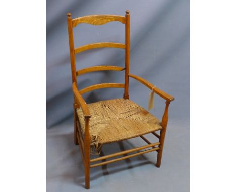 An early 20th century oak ladder back armchair with rush seat. (a/f) 