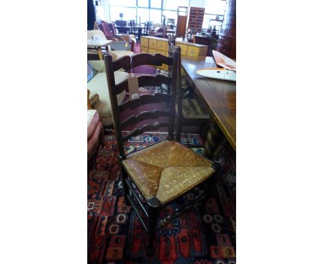 A set of six early 20th century oak ladder back dining chairs with rush seats. 