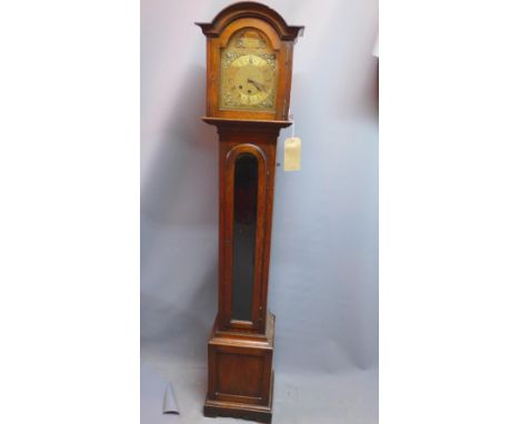 An early 20th century oak longcase clock, the broken arch brass dial with Roman numerals, the case with arched pediment, the 