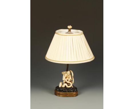 A JAPANESE CARVED IVORY FIGURE of a man wrestling a snake, on a naturalistic base, mounted as a table lamp, 17" high, Meiji. 