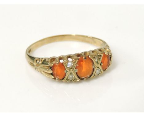 A 9ct gold three stone fire opal boat shaped ring, set with pairs of diamond set points, with F Hinds certificate and receipt