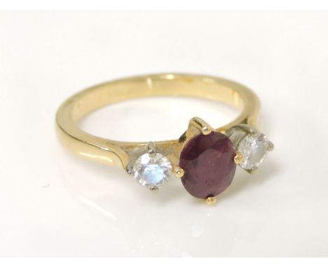 A gold ruby and diamond three stone ring, tested as approximately 18ct gold