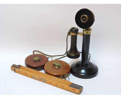 A candlestick telephone, two leather tape measures by Rabone & Sons and Chesterman, and a folding rule