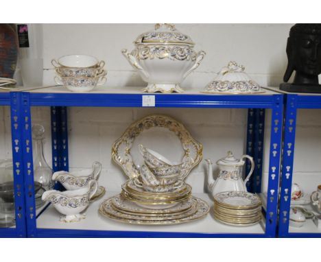A Spode gilded and blue scrolling foliate design dinner service, including tureens, serving platters, gravy boats and other i