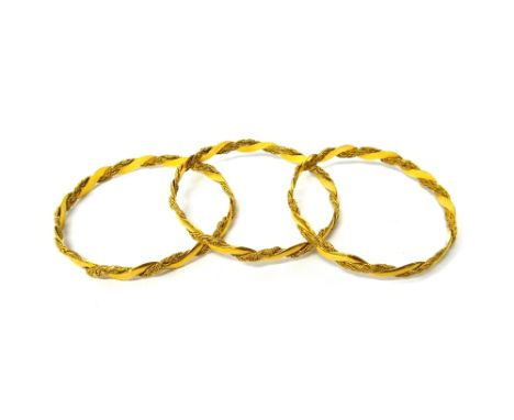 Three gold circular bangles, each in a ropetwist interwoven wirework and serpentine link design, detailed 22 K, combined weig