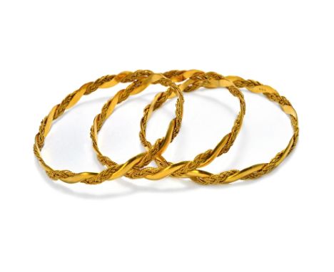 Three gold circular bangles, each in a ropetwist interwoven wirework and serpentine link design, detailed 22 K, combined weig