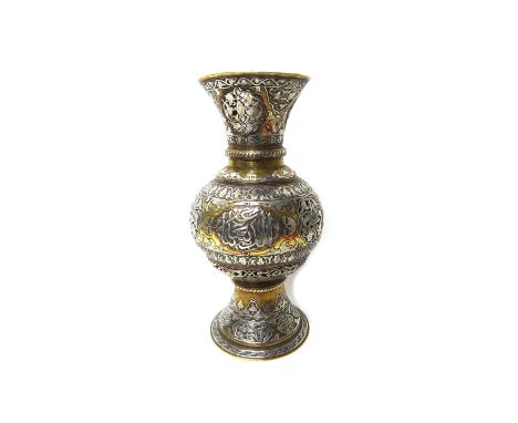 An Islamic silvered and brass pierced lamp, late 19th/early 20th century, of baluster form, pierced with foliate panels and e