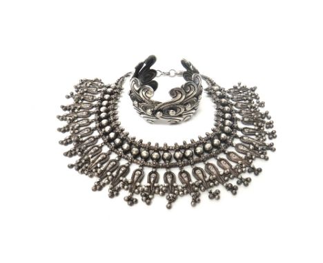 An Eastern collar necklace, formed as a row of tapered pendant drops, fitted with bead terminals, on a two row woven link cha