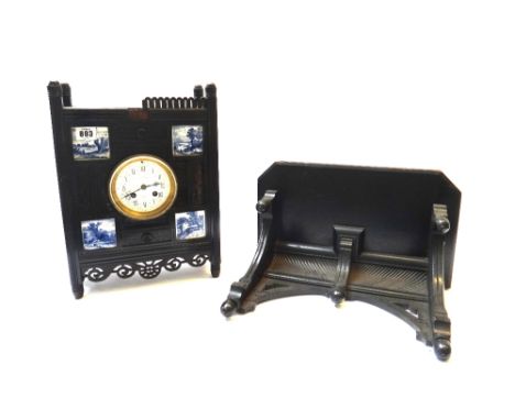 An Aesthetic movement ebonised bracket clock, late 19th century, the carved rectangular body inset with four blue and white c