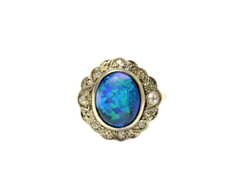 A gold and platinum, opal and diamond set oval cluster ring, mounted with the oval opal at the centre, within a surround of c