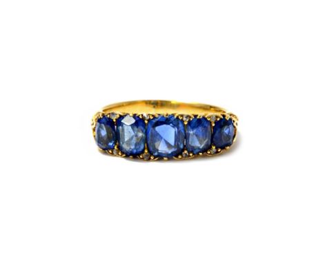 A gold and sapphire set five stone ring, mounted with a row of cushion shaped sapphires graduating in size to the centre ston