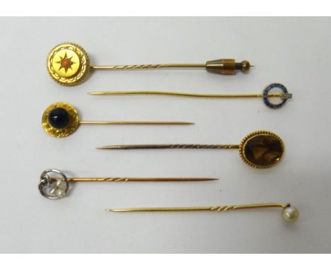 A French gold, sapphire and diamond set stick pin, having a circular top, a gold and coral set stick pin, a citrine set singl