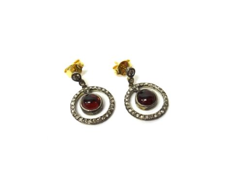 A pair of carbuncle garnet and diamond set pendant earrings, each with a circular carbuncle garnet at the centre, within a su