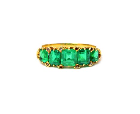 A gold and emerald set five stone ring, mounted with a row of rectangular cut emeralds graduating in size to the centre stone