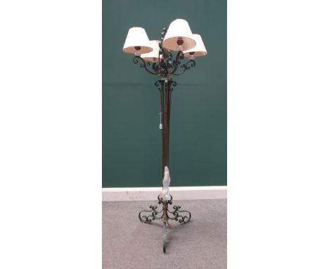 A green painted four branch wrought iron standard lamp, 20th century, with clear cut crystal sconces over scrollwork arms and