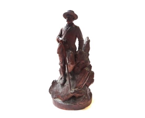 A Black Forest walnut carved figure, late 19th/early 20th century, modelled as a smartly dressed gentleman with a long walkin