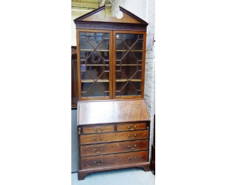 A 19th century marquetry inlaid mahogany bureau bookcase, the broken architectural cornice over a pair of astragal glazed doo