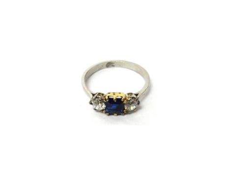 A sapphire and diamond set three stone ring, mounted with a square step cut sapphire at the centre, between two cushion shape