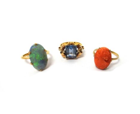 A gold ring, claw set with an oval opal, a gold ring, claw set with a carved coral oval cameo, designed as the portrait of a 