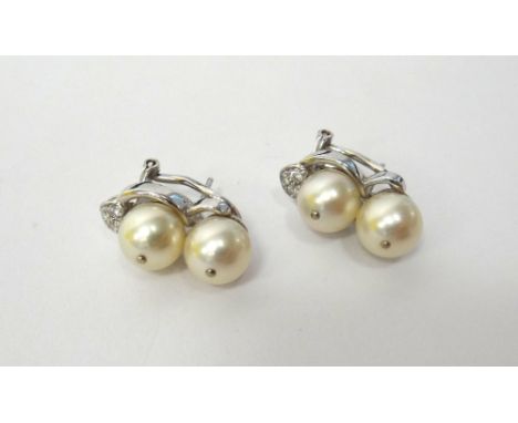 A pair of white gold, cultured pearl and diamond set earclips, each mounted with two cultured pearls and with a diamond set t