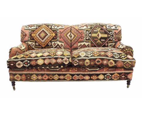Good George Smith two seater settee, with woven coloured Kilim upholstery, supported upon turned legs with brass caps and cas