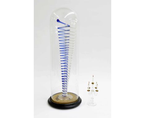 Glass frigger of three dimensional Jacob's ladder, with a blue and white spiral, upon a circular wooden plinth and under a gl