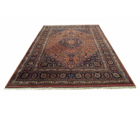 Large Persian carpet, on a rose pink ground, with central floral medallion with multiple flower head borders around, 11.5' x 