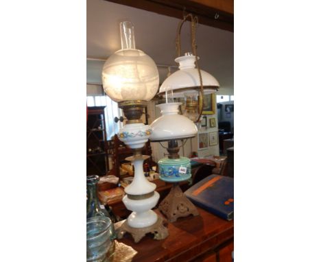 Two oil lamps with glass reservoirs (one painted), and a hanging oil lamp with clear glass reservoir