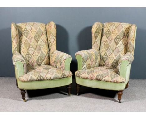 A pair of late Victorian low wing back easychairs upholstered in floral tapestry and green dralon, on turned front legs and c