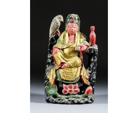 A Chinese carved polychrome and giltwood seated figure of Guanyin Pusa holding a scroll in her left hand, a vase by her elbow