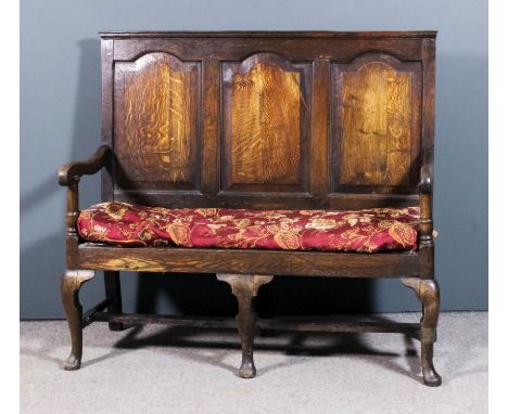 An 18th Century panelled oak settle of small proportions, the rectangular back inset with three shaped and fielded panels, th