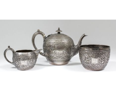 A late Victorian silver spherical three piece tea service, the whole embossed with Near Eastern figures, within scroll and fl