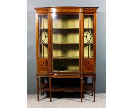 An Edwardian mahogany bow and break-front display cabinet, the whole inlaid with stringings and satinwood crossbanding, with 