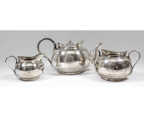 A late Victorian silver three piece tea service, the plain squat, circular bodies with bead mounts to rims and partly reeded 