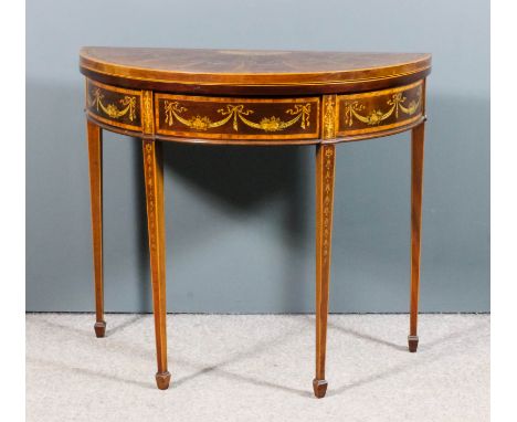 An Edwardian "Sheraton Revival" mahogany D-shaped card table, the whole inlaid with satinwood bandings, ribbon and bellflower