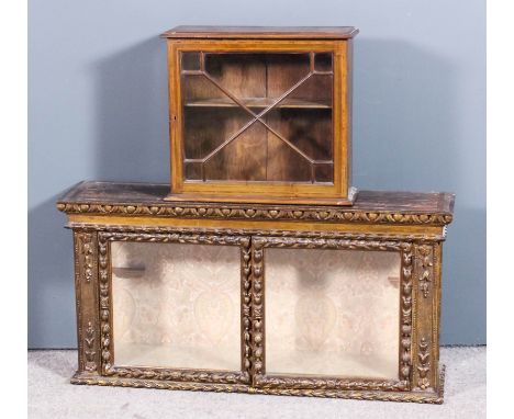 An early 20th Century gilt wall mounted display cabinet of "Georgian" design with dark moulded cornice, fitted one plate glas