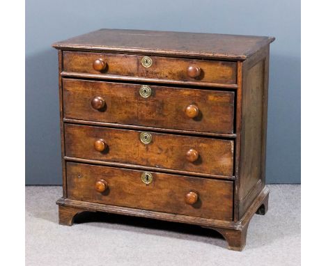 An 18th Century panelled oak chest with plain top and rounded edge mouldings, fitted four long graduated drawers, with later 