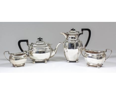 A George V silver rectangular four piece tea service with panelled bodies, angular loop handles and on flat bun feet, compris