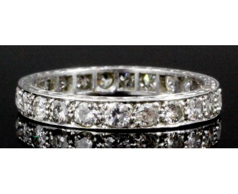 A 1930's silvery coloured metal mounted all diamond set full hoop eternity ring, the face channel set with twenty-eight old c