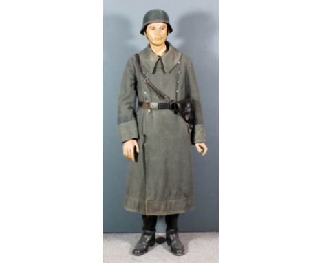 A German World War II soldier's uniform comprising - great coat and trousers, leather belt and holster and tin helmet and boo