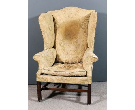 A mahogany wing back easy chair of "Georgian" design upholstered in floral tapestry, on square moulded front legs and H-patte
