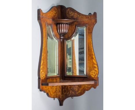 An Edwardian rosewood hanging corner shelf of shaped outline, with shaped cresting and apron, the whole inlaid with leaf scro