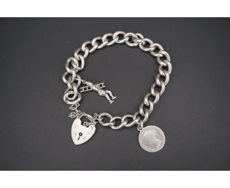 A white metal curb link charm bracelet, with heart shaped padlock clasp, Victorian coin fob, and charm in the form of a top-h