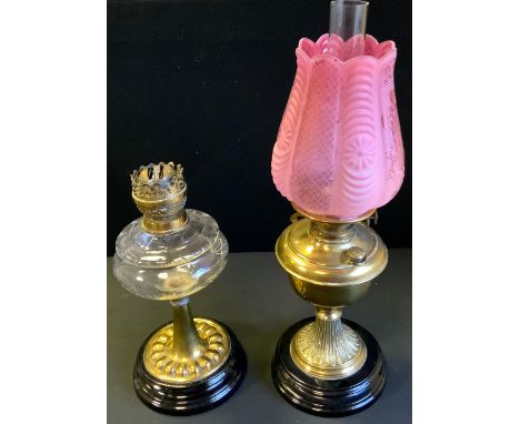 A Victorian brass oil lamp, cranberry glass shade, duplex burner, ebonised base, 55cm tall, c.1890;  another Victorian glass 