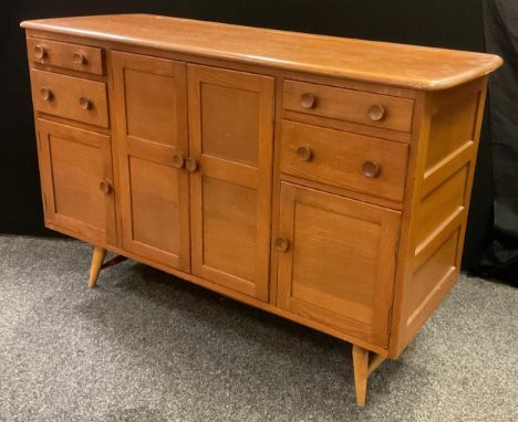 A mid 20th century Ercol sideboard, elm plank top, two large and two small panelled doors, panelled sides, four drawers, spla