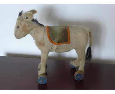 STEIFF DONKEY ON WHEELS, BLACK BOOT BUTTON EYES (1 MISSING), COTTON MANE AND TIP OF TAIL, SADDLE BLANKET WITH RED TRIM ON BLU